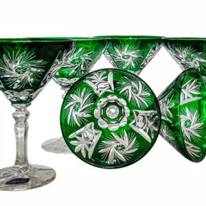 Può includere: Set di sei bicchieri da martini in cristallo verde smeraldo. Ogni bicchiere presenta un motivo a stella inciso trasparente. I bicchieri hanno una classica forma a martini con un lungo stelo e un'ampia coppa triangolare.