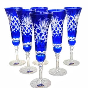Può includere: Sei flûte da champagne blu cobalto con intricati disegni in vetro tagliato bianco. Le flûute hanno una forma alta e sottile con stelo e base trasparenti. Il motivo in vetro tagliato include motivi a diamante e floreali.