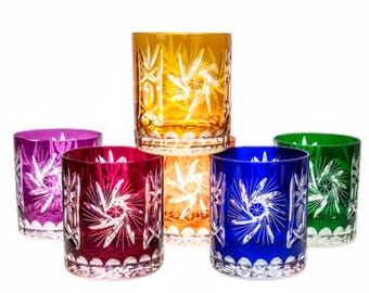 May include: Set of six crystal glasses with a starburst design. The glasses are in various colors, including purple, red, orange, yellow, blue, and green.