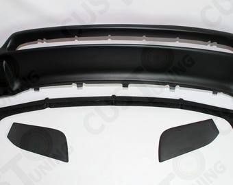 May include: A black plastic car bumper with a lower lip spoiler and two side pieces. The bumper is designed to be added to the front of a car.