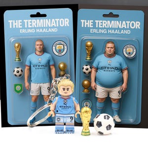 May include: Two action figure sets and a keychain featuring a soccer player in a light blue jersey with the text "ETIHAD AIRWAYS". The packaging reads "THE TERMINATOR ERLING HAALAND". Accessories include a soccer ball and a trophy.