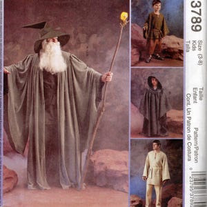 May include: A sewing pattern envelope labeled 3789 for kids sizes 3-8. The cover displays a wizard costume with a long grey robe, pointed hat, white beard, and staff, alongside smaller images of a tunic, pants, and a hooded cloak for children.