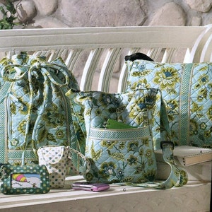 May include: A Simplicity sewing pattern for a quilted bag, with a floral print in shades of blue and green. The pattern is for one size and includes instructions for making a tote bag, a crossbody bag, and a small pouch.