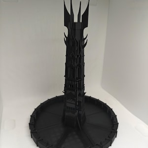 Peut inclure: Modèle 3D imprimé en noir de la Tour Sombre du Seigneur des Anneaux. La tour est haute et mince avec un sommet pointu et une base circulaire.
