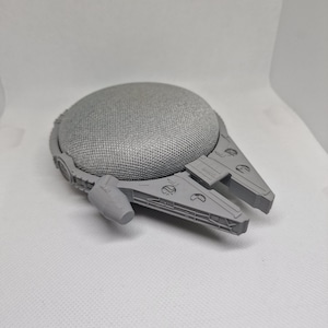 May include: A grey 3D printed model of the Millennium Falcon spaceship from Star Wars. The model is designed to be used as a speaker.