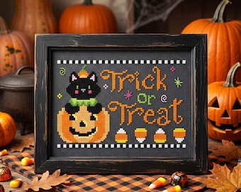 May include: A framed cross-stitch art piece featuring a black cat sitting on a jack-o'-lantern, with the orange text Trick Or Treat, small candy corn icons, and a black and white checkered border, all set against a dark gray background.