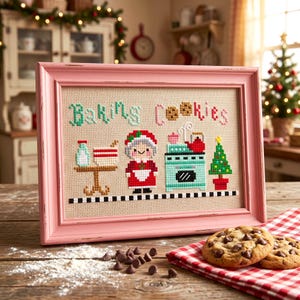 May include: A framed cross-stitch artwork with a pink frame, depicting a baking scene. The text "Baking Cookies" is stitched in green and pink. The artwork includes a table with a cake, a woman in a red dress, an oven, and a Christmas tree. Chocolate chip cookies are on a red and white checkered cloth.