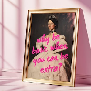 May include: A framed print of a woman in a white dress with a crown on her head. The text "why be basic when you can be extra?" is written in pink on the print.