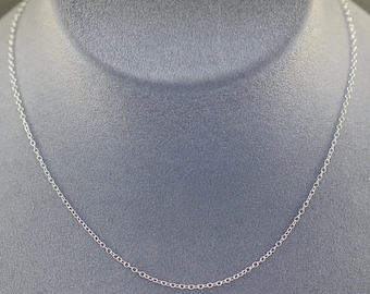 May include: A silver chain necklace on a gray velvet display stand.