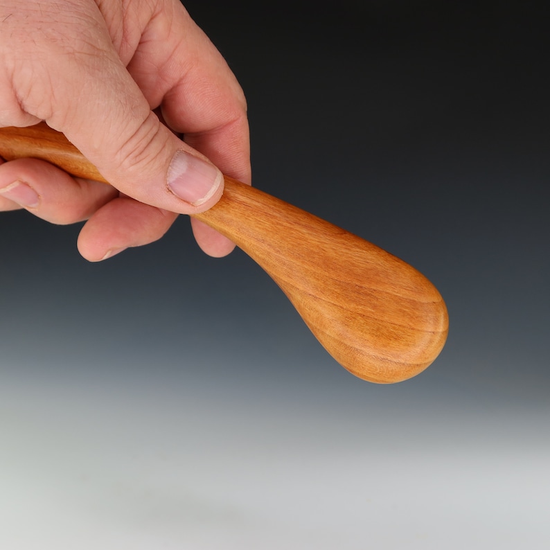 May include: A wooden spoon with a teardrop-shaped bowl and a curved handle.
