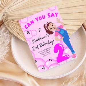 May include: Pink birthday invitation with a cartoon girl in overalls and a pink number 2 balloon. The text reads "Can you say Maddison's 2nd Birthday!" with details for the party.