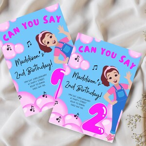 Pu&ograve; includere: Un invito di compleanno blu e rosa con una ragazza dei cartoni animati che canta. L'invito dice "Can You Say" e "Maddison's 2nd Birthday!" con i dettagli per la festa.