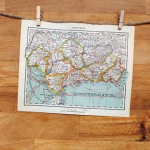 Può includere: Una mappa vintage dell'Andalusia, Spagna, con uno sfondo blu chiaro e linee rosse, gialle e verdi che mostrano i confini e le strade della regione. La mappa è etichettata "Andalusia" e "Mediterraneo" e include una barra di scala.