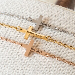 May include: Three cross necklaces in silver, gold, and rose gold. Each cross is attached to a chain and has engraved text. The silver necklace reads "Psalm 23", the gold necklace reads "Emma & Ava", and the rose gold necklace reads "Est. 2025".