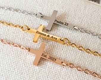 May include: Three cross necklaces in silver, gold, and rose gold. Each cross is attached to a chain and has engraved text. The silver necklace reads "Psalm 23", the gold necklace reads "Emma & Ava", and the rose gold necklace reads "Est. 2025".
