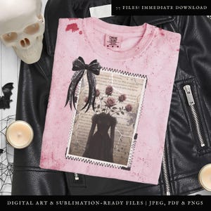 K&ouml;nnte beinhalten: Ein rosa T-Shirt mit einem abgenutzten Look, das mit einer schwarzen Schleife und einer Vintage-Illustration einer Frau verziert ist, aus deren Kopf Rosen wachsen. Die Illustration ist mit einem gestickten Rand gerahmt und hat einen abgenutzten, alten Look.