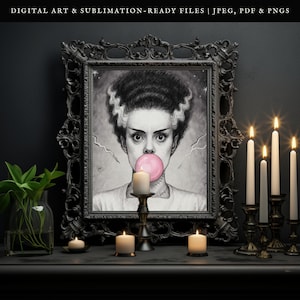 May include: Black and white framed artwork of a woman with a pink bubble gum bubble. The artwork is in a black ornate frame. Lit candles in brass holders and a vase of greenery are in front of the artwork.