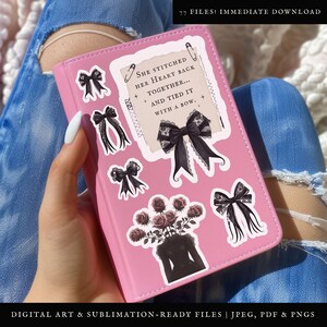 K&ouml;nnte beinhalten: Ein rosa Notizbuch mit mehreren schwarzen und wei&szlig;en Aufklebern mit einem Zitat &uuml;ber das Zusammenn&auml;hen eines Herzens, einer schwarzen Schleife und einem Rosenstrau&szlig;. Der Text auf dem Aufkleber lautet "Sie hat ihr Herz wieder zusammengen&auml;ht... und mit einer Schleife gebunden."