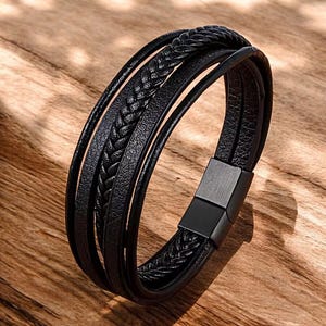 May include: Black leather bracelet with a braided design and a magnetic clasp.