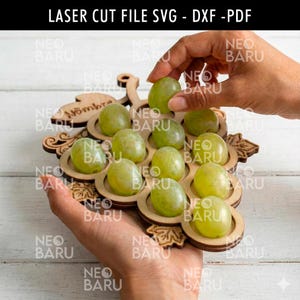 Könnte beinhalten: Ein lasergeschnittenes, traubenförmiges Serviertablett aus Holz mit grünen Trauben. Das Tablett hat kreisförmige Vertiefungen für jede Traube. Der Text "LASER CUT FILE SVG - DXX - PDF" steht oben.