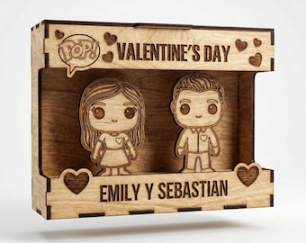 May include: Wooden Valentine's Day display featuring two cartoon figures, a man and a woman, inside a box frame. The words "Valentine's Day" and "Emily Y Sebastian" are engraved on the frame, along with heart and "Pop!" speech bubble designs.
