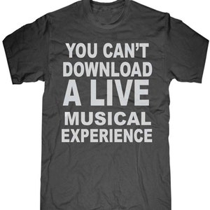 May include: Dark gray t-shirt with the white text "YOU CAN'T DOWNLOAD A LIVE MUSICAL EXPERIENCE". The shirt has a crew neck and short sleeves. The text is centered on the front of the shirt.