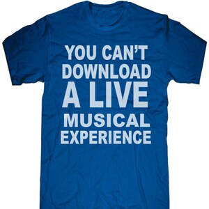 May include: A royal blue t-shirt with the white text: "YOU CAN'T DOWNLOAD A LIVE MUSICAL EXPERIENCE". The shirt has a crew neck and short sleeves. The text is centered on the front of the shirt.