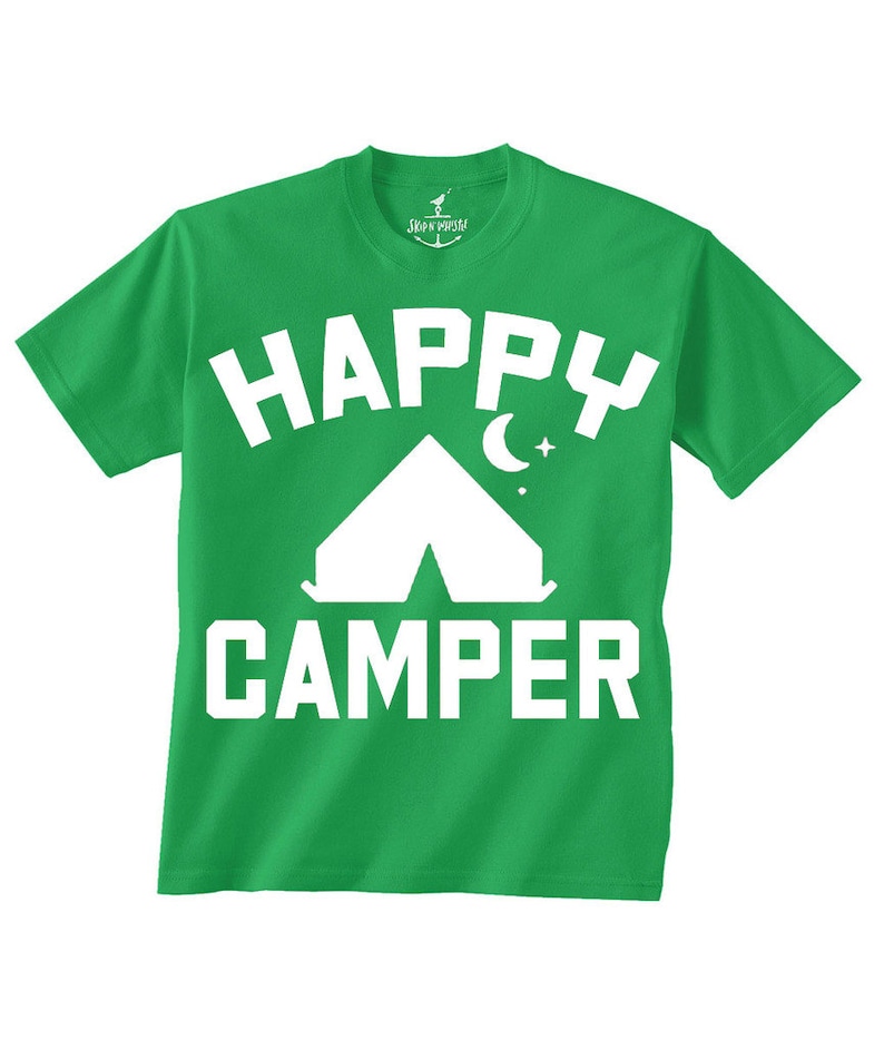 以下が含まれることがあります： 「HAPPY CAMPER」の文字が大きく白でプリントされた緑色のTシャツ。白いテント、月、星のグラフィックが「HAPPY」の下にあります。Tシャツはクルーネックで半袖です。