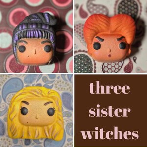 May include: A collage featuring three Funko Pop figures, each representing a witch character. One has purple hair, another has orange hair, and the third has yellow hair. The text "three sister witches" is displayed in a brown box.