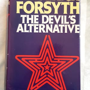 May include: A vintage hardcover book by Frederick Forsyth, titled "The Devil's Alternative". The cover is a deep blue with yellow lettering and a red star design. The book is likely a first edition.