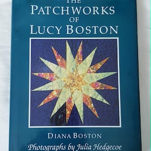 May include: A teal-covered book titled "The Patchworks of Lucy Boston". The cover displays a starburst quilt design within a square frame. The author is Diana Boston, with photographs by Julia Hedgecoe.