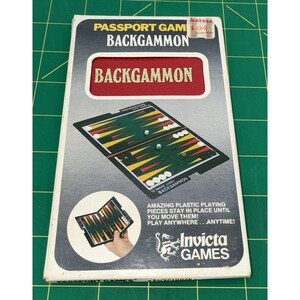 May include: A vintage Passport Games Backgammon set in its original box. The box features the game's name in bold red letters and an illustration of the game board. The set includes dice and plastic playing pieces. The Invicta Games logo is visible.