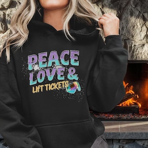 May include: Black hoodie with the words "PEACE LOVE & LIFT TICKETS" in a colorful design. The text is in purple, teal, and yellow. The hoodie has a drawstring hood and long sleeves.