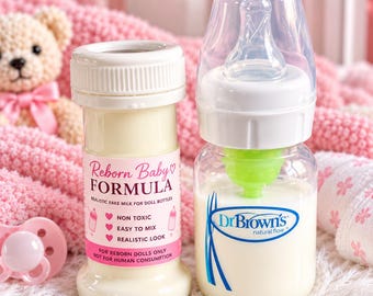 Könnte beinhalten: Eine weiße Kunststoffflasche mit Reborn Baby Formula und einem rosa Etikett mit Text und Symbolen, neben einer transparenten Dr. Brown's Babyflasche mit cremeweißer Flüssigkeit, weißem Verschluss, durchsichtigem Sauger und grünem Ventil.