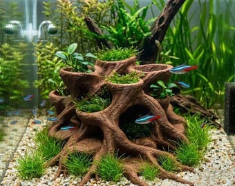 May include: A brown, textured resin tree root ornament with multiple hollow openings for aquatic plants, positioned in a freshwater aquarium with light-colored gravel substrate and several small neon tetra fish swimming nearby.