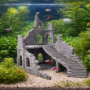 May include: A grey, stone-like aquarium ornament depicting a ruined castle with arched windows, stairs, and a weathered appearance. The castle is surrounded by green aquatic plants and small fish.