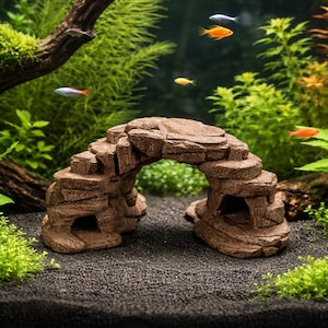 May include: A brown, rock-like aquarium decoration with an archway, surrounded by lush green plants and small, colorful fish. The scene is set in an aquarium with a dark substrate, creating a natural underwater environment.