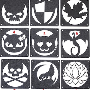 Peut inclure: Neuf panneaux décoratifs en métal noir avec divers motifs découpés. Les motifs comprennent un crâne, un bouclier, une feuille d'érable, un chat, un chat avec des yeux en forme de cœur, un dragon, un crâne et des os croisés, un loup hurlant et une fleur de lotus.