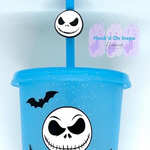 Puede incluir: Un vaso azul claro con una pajita a juego y un dise&ntilde;o de Jack Skellington. El vaso presenta un murci&eacute;lago negro y una gran cara de Jack Skellington. La pajita tiene un dije con la cara de Jack Skellington. El vaso est&aacute; decorado con purpurina.