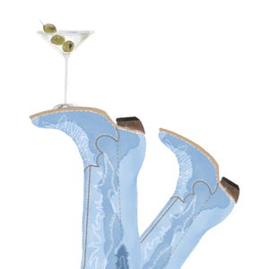 May include: A pair of light blue cowboy boots with intricate stitching, one boot is holding a martini glass with olives.