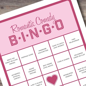 Peut inclure: Une carte de bingo rose et blanche avec le titre "Romantic Comedy B*I*N*G*O" et des cases contenant des phrases comme "Rencontre la famille ou des amis proches", "Contact physique accidentel", "Grand geste romantique", "Le meilleur ami donne des conseils", "La nourriture est partagée", "Mariage interrompu", "La pluie ou le spectacle les rapproche", "Une trahison ou une révélation", "Les spectateurs applaudissent", "Une fausse relation", "Court pour attraper l'intérêt amoureux", "Dysfonctionnement de la garde-robe", et "Un pari est placé, un défi est".