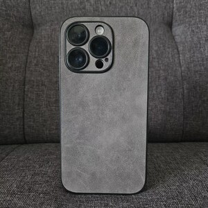 May include: A grey phone case with a textured finish. The case has a black camera bump with three lenses.