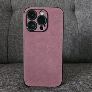 May include: A mauve phone case with a black camera bump and four black camera lenses.