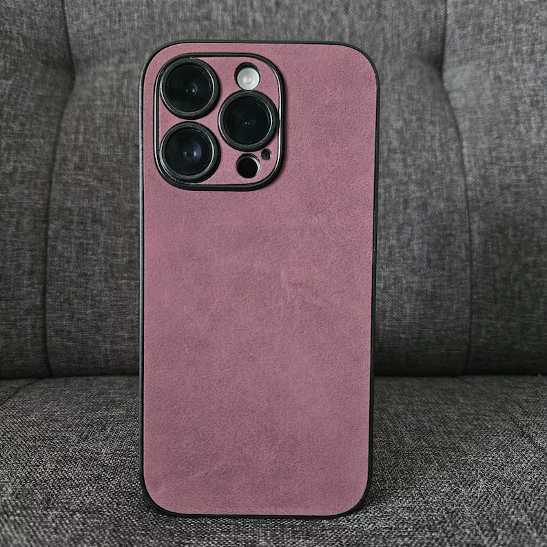 May include: A mauve phone case with a black camera bump and four black camera lenses.