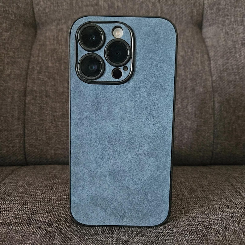 May include: A blue phone case with a textured finish. The case has a raised camera bump with four black camera lenses.