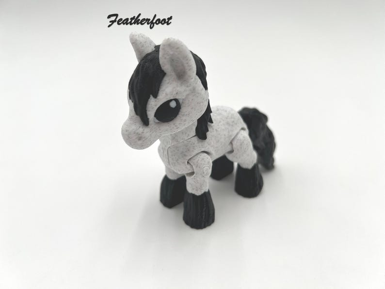 May include: A small, gray and black toy horse with articulated legs. The horse has a black mane and tail.