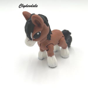 May include: A brown and black Clydesdale horse figurine with white hooves. The figurine is made of plastic and has a jointed head, legs, and tail.