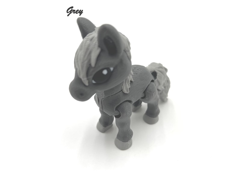 May include: A grey toy horse with a white mane and tail. The horse has articulated legs and a friendly face.