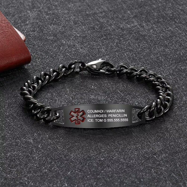 May include: Black medical ID bracelet with a chain link design. The ID plate has a red medical symbol and text: COUMADI / WARFARIN, ALLERGIES: PENICILLIN, ICE: TOM G 555.555.5555.