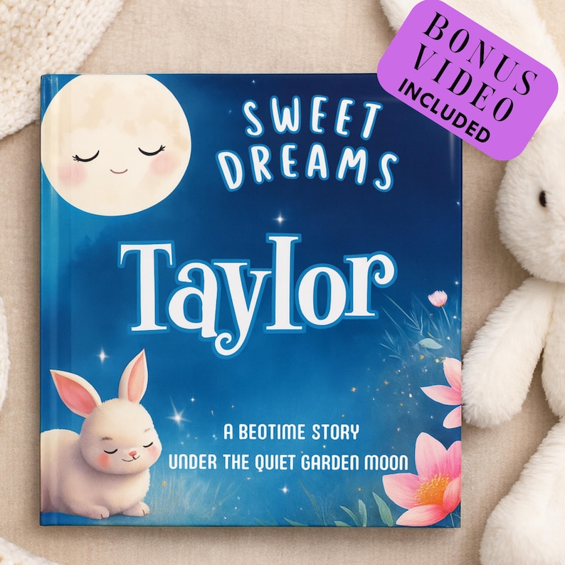 May include: A children's book titled "Sweet Dreams Taylor" with a blue cover featuring a smiling moon, a white bunny, and pink flowers. The book includes a bonus video. A plush bunny is in the background.